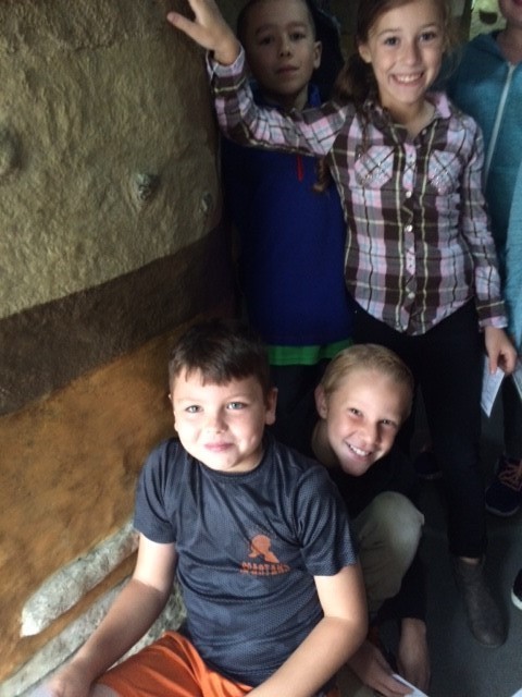 kids next to a cave wall